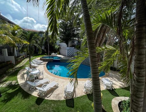 a pool with chairs and palm trees in a yard at Blue Palm - Isla de Margarita in Paraguachi