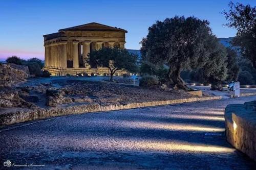 a building on a hill with trees and a road at I Tetti di Girgenti in Agrigento