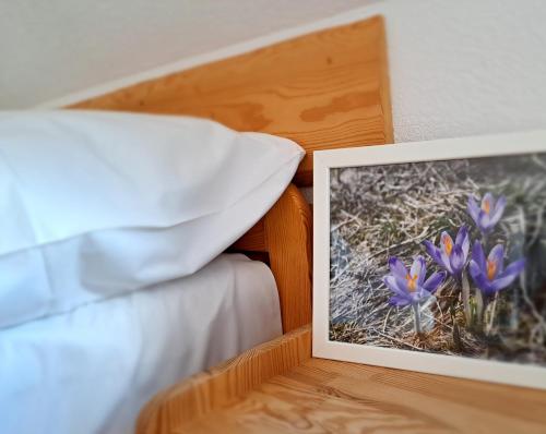 a picture of purple flowers next to a bed at Przy Szlaku Zakopane centrum pokoje & apartamenty in Zakopane