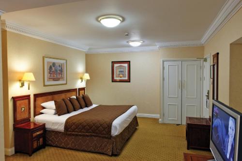Habitación de hotel con cama y TV de pantalla plana. en Grange Clarendon Hotel en Londres