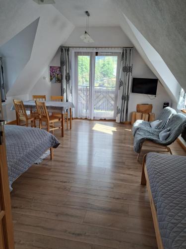 a living room with a table and a dining room at Przy Szlaku Zakopane centrum pokoje & apartamenty in Zakopane