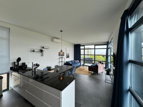 a kitchen and living room with a view of the living room at Enkhuizer Strand Chalet Strandpanorama Zweite Reihe mit Zaun Hausnr 203 in Enkhuizen