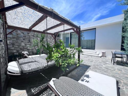 a patio with a couch and some chairs at Olivujoj Villajoj - Deluxe Villa with Detached Pool House in Anavissos
