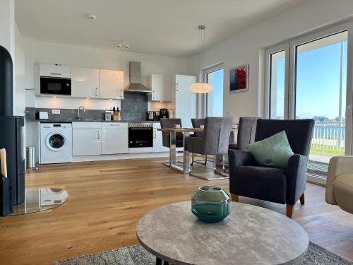 a living room and kitchen with a table and chairs at Ferienwohnung eastside App 3 Olpenitz in Olpenitz