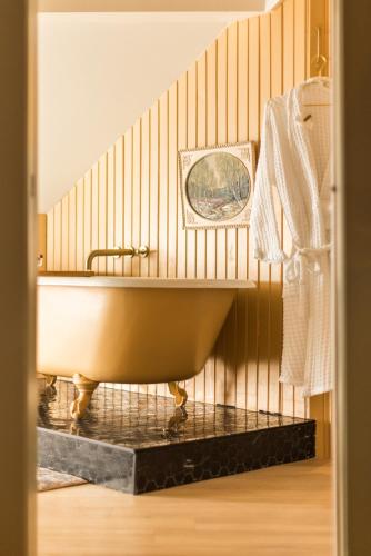 a bath tub in a bathroom with a wooden wall at Dvele Inn in St. John's
