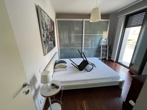 una camera con un letto bianco con una lampada e una sedia di La Ginestra di Lido di Camaiore a Camaiore