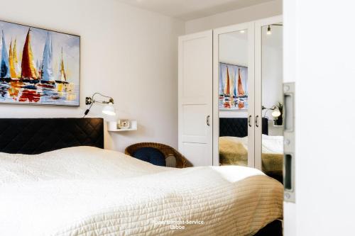ラーボエにあるKapitänshaus W01のベッドルーム1室(ベッド1台付)が備わります。壁には絵画が飾られています。