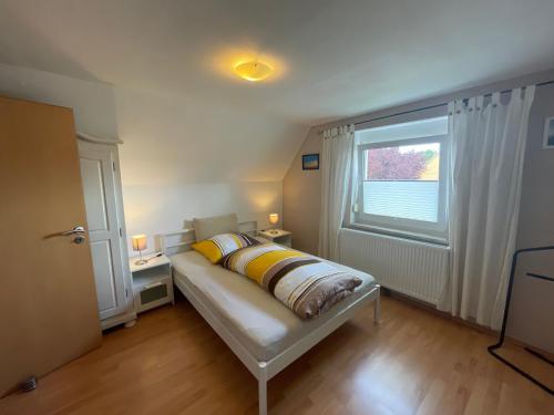 ein Schlafzimmer mit einem Bett mit gelben Kissen und einem Fenster in der Unterkunft Feld PU1 in Laboe