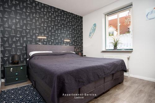 a bedroom with a bed with a black accent wall at Fewo 4 Knotenpunkt in Laboe