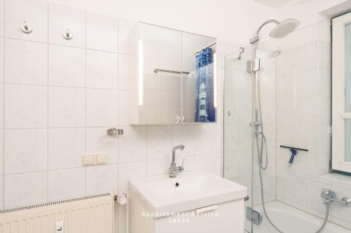 a white bathroom with a sink and a shower at Fewo 4 Knotenpunkt in Laboe