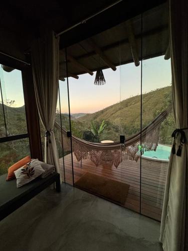 a bedroom with a large window with a view of a pool at Rustik in Alto Paraíso de Goiás