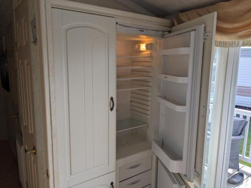 a white refrigerator with its doors open in a room at i7 Millfields 6 Berth Luxury Caravan DG & GCH Familys Only And Lead Person Must Be Over 30 in Ingoldmells