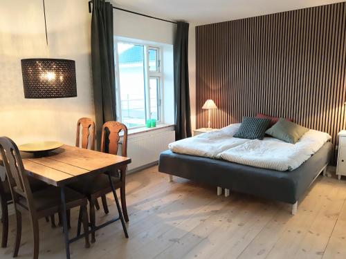 a bedroom with a bed and a table and a dining room at Mols Bed & Breakfast in Knebel