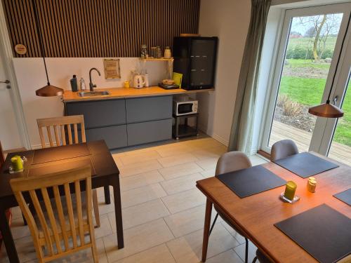 a kitchen and dining room with a table and chairs at Mols Bed & Breakfast in Knebel