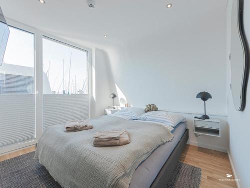 a bedroom with a large bed with towels on it at Hausboot Floating Homes - A-Type Laboe FH-LA-03 Baltic Bay in Laboe