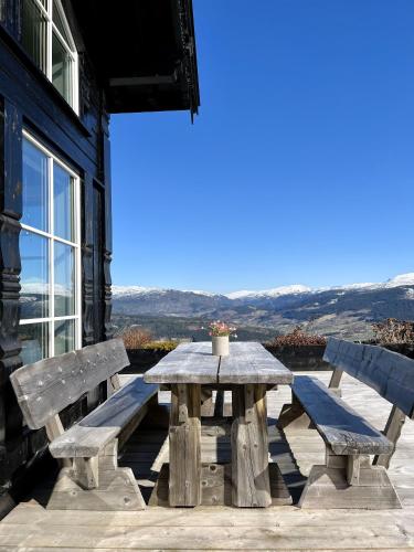 a wooden picnic table with two benches on a patio at Voss Resort self-service apartments in Skulestadmo