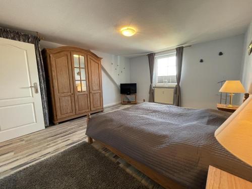 a bedroom with a large bed and a television at Wiesenweg W16 in Laboe