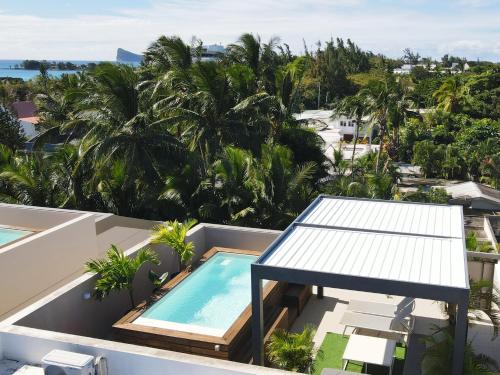 a view from the balcony of a resort with a swimming pool at Villa Eden-2 bedrooms with Private Rooftop Terrace & Pool & access to private beachclub, Ki Residences, Pereybère, Grand Baie in Grand Baie