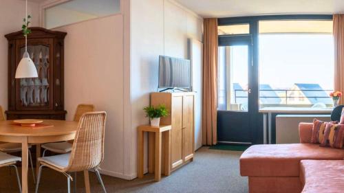 ein Wohnzimmer mit einer Couch und einem Tisch mit einem Fernseher in der Unterkunft Leuchtfeuer in Wendtorf