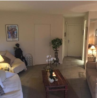 a living room with a couch and a table at A charming apartment in the heart of the French Riviera in Mandelieu-la-Napoule