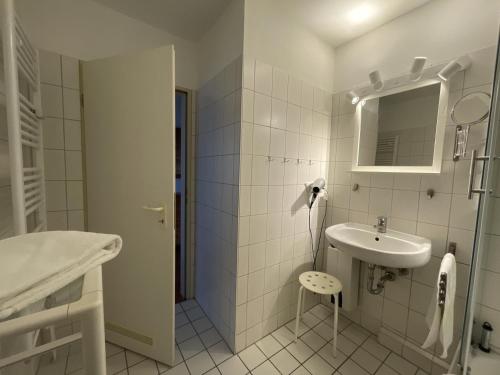 ein weißes Badezimmer mit einem Waschbecken und einem Spiegel in der Unterkunft Wiesenweg W12 in Laboe