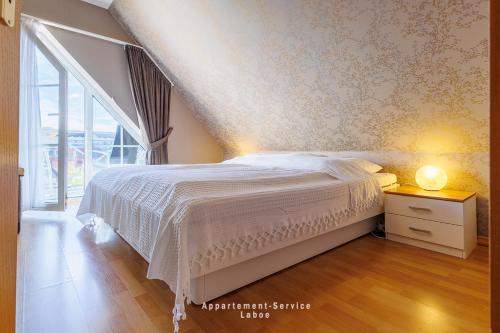 a bedroom with a white bed and a window at Bellevue W10 in Laboe