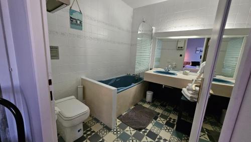 a bathroom with a tub and a toilet and a sink at Auberge de la Marine in Losne