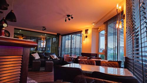 a restaurant with a table and chairs and windows at Auberge de la Marine in Losne