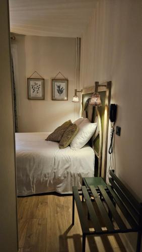 a bedroom with a bed with a bench next to it at Auberge de la Marine in Losne