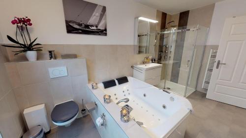ein Badezimmer mit einer Badewanne, einem WC und einem Waschbecken in der Unterkunft Haus Friedrichstr. 16a in Laboe