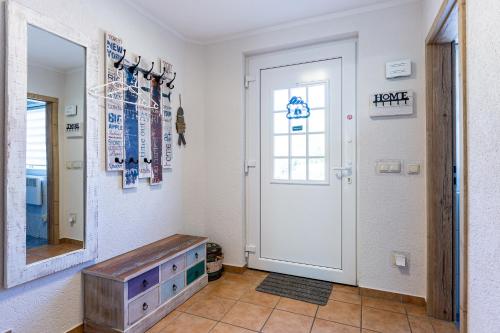 a hallway with a white door and a mirror at Ostseeromantik in Neuhaus