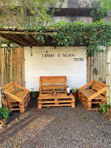 two wooden benches sitting in front of a wall at Hotel Puerto Libertad - Iguazú in Puerto Libertad