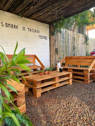 a patio with two wooden benches in a building at Hotel Puerto Libertad - Iguazú in Puerto Libertad