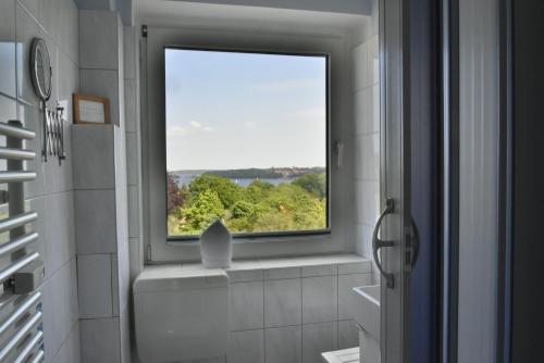 een badkamer met een raam met uitzicht bij fewo1846 - Ostseebad - Apartment mit 2 Schlafzimmern und Meerblick in Flensburg