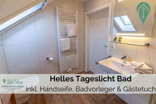 a bathroom with a sink and a mirror at Ferienwohnung Behle in Krummhörn