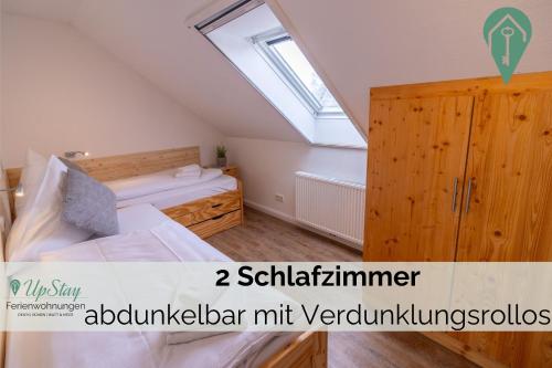 a bedroom with a bed and a large window at Ferienwohnung Behle in Krummhörn