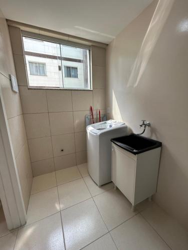 ein Bad mit einer Waschmaschine und einem Fenster in der Unterkunft Kitnet 4 in Rio Negrinho