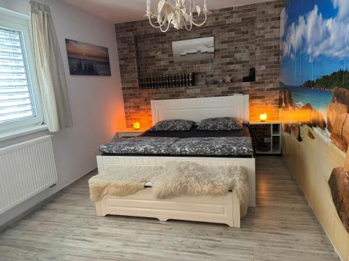 1 dormitorio con cama y pared de ladrillo en Apartmán s garáží a balkónem, en Plzeň