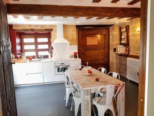 a kitchen with a wooden table and white cabinets at Casa Rural Los Carros in San Asensio
