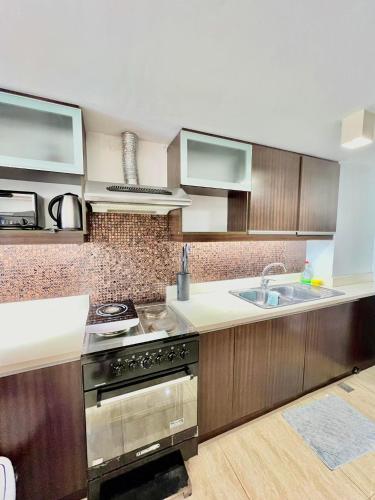 a kitchen with a stove and a sink at Home-like 2BR Unit in the Center in Cebu City