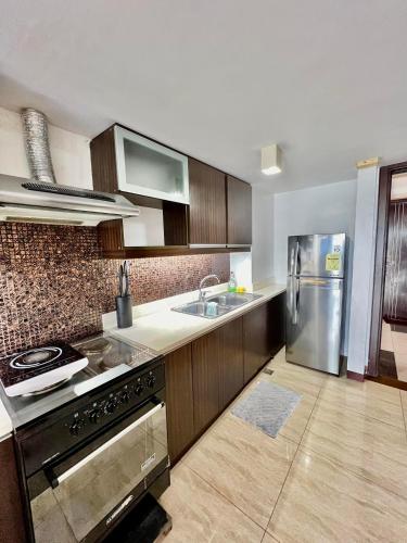 a kitchen with a stainless steel refrigerator and a sink at Home-like 2BR Unit in the Center in Cebu City