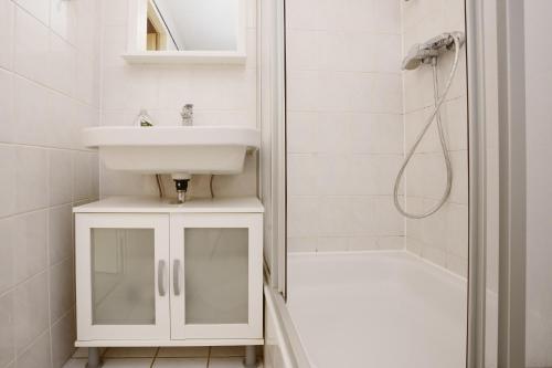 y baño blanco con lavabo y ducha. en Erholungszentrum FeWo 25, en Laboe