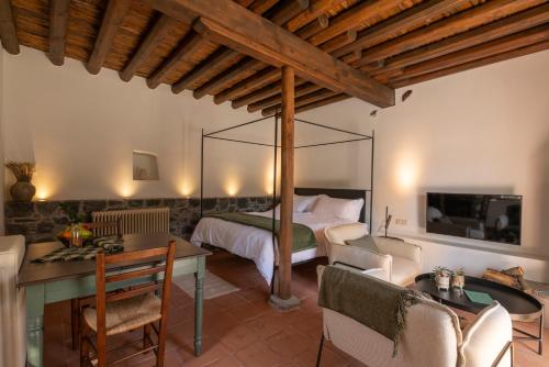 a bedroom with a bed and a table and chairs at Casa Oliva Guesthouse in Tris Elies