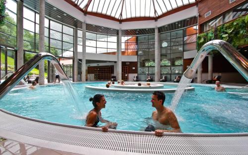 two men in a swimming pool in a building at Gîte chalet la Bergerie de Sentantony - Val d'Azun - Montagne Pyrénées in Bun