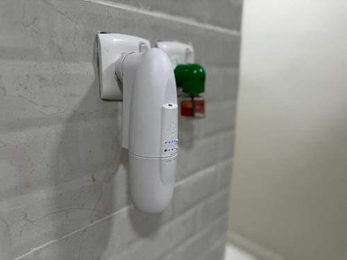 a white phone on a wall in a bathroom at راكة سويت الخبر للشقق الفندقية المخدومة in Al Khobar