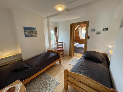 a bedroom with two beds and a hallway at FeWo Lohmann in Laboe