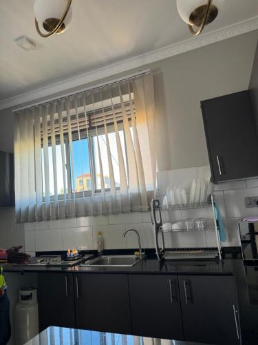 a kitchen with a sink and a window at Muntaha homes in Kampala
