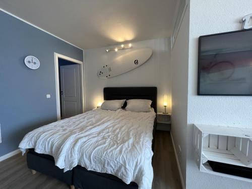 a bedroom with a bed with a surfboard on the wall at Meerblickbude in Wendtorf