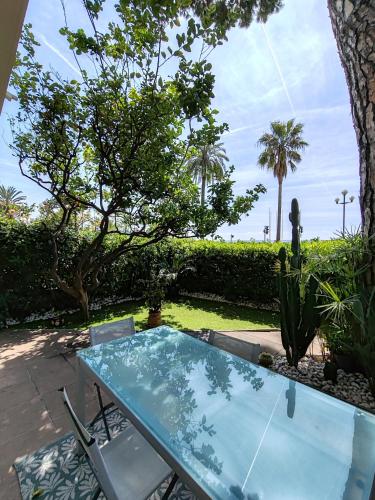 une table et des chaises en verre sur la terrasse dans l'établissement Garden Atlantide Promenade, à Nice