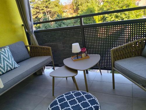 a balcony with a couch and a table and a window at Zmaj 94 in Bečej